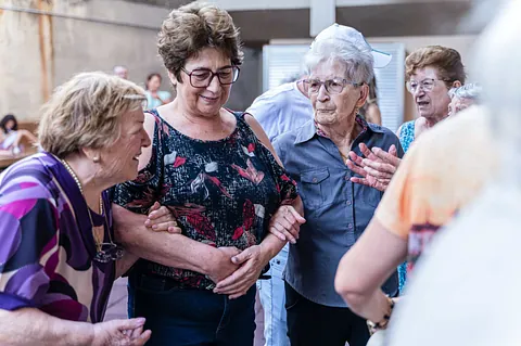 Eine Gruppe junger Menschen arbeitet gemeinsam an Laptops um einen Tisch.