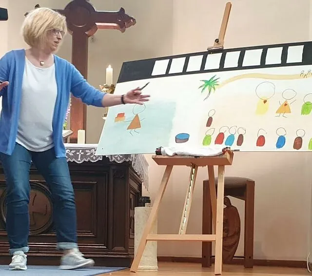 Frau präsentiert Zeichnung im Gottesdienst.